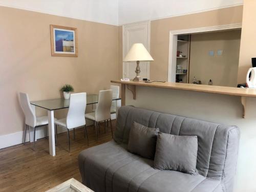 una sala de estar con un sofá y una mesa en Appartement Trouville Plage, en Trouville-sur-Mer