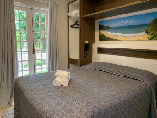 a bedroom with a bed with two towels on it at Hotel São Sebastião da Praia in Florianópolis