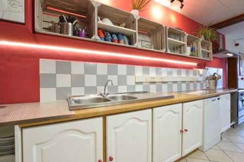 a kitchen with white cabinets and a sink at L'orée du bois in Roy