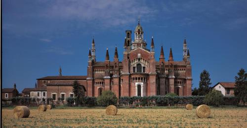 a large building with hay bales in front of it at Il nido della cicogna in Certosa di Pavia