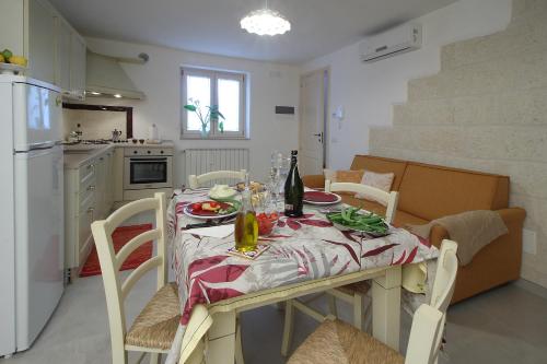 a kitchen with a dining table and a kitchen with a white refrigerator at Da nonno in Pezze di Greco