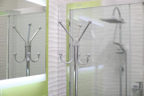 a shower with a glass door and a mirror at Bed Nonnonino in Porto Cesareo