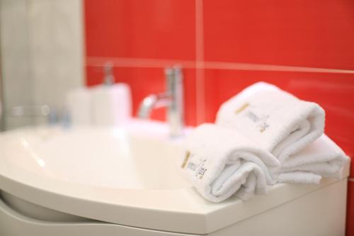 a bathroom with white towels sitting on a sink at Bed Nonnonino in Porto Cesareo