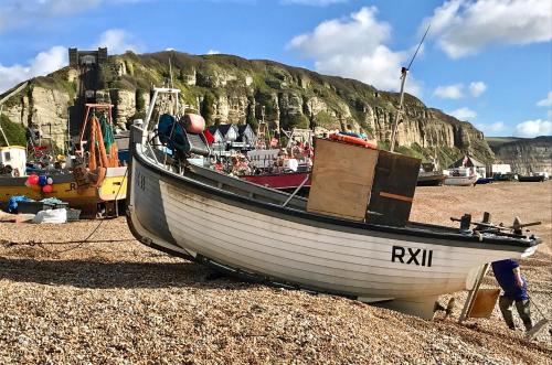 a boat sitting on the ground on a beach at The Laindons in Hastings