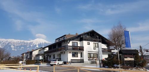 a building with a snow covered mountain in the background at Hotel GH Kolinska in Bled