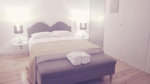 エヴォラにあるÉvora Art&Accommodationのベッドルーム1室(大型ベッド1台、折りたたみ式タオル2枚付)