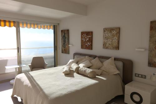 a bedroom with a large bed with a large window at Port Marina Baie des Anges in Villeneuve-Loubet