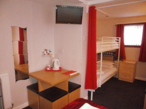 Dormitorio con litera, escritorio y litera en The Withnell Hotel en Blackpool