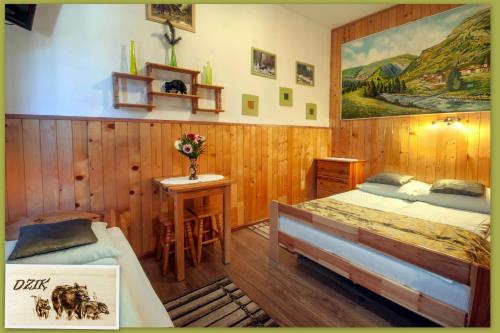 a bedroom with two beds and a table with flowers at Hubertus Pokoje Gościnne in Sienna