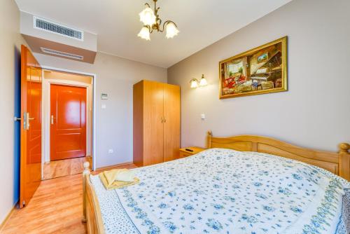 a bedroom with a bed with a blue and white comforter at Willa Joker in Krynica Morska