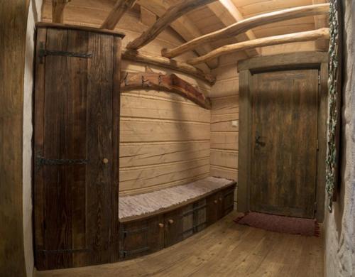 a room with a bed and a wooden door at Hobití dom in Spišský Štiavnik