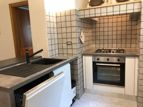 a kitchen with a sink and a stove at Dimora del '500 -City Apartment San Vito in San Vito dei Normanni