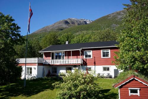 een rood-wit huis met een berg op de achtergrond bij Olderdalen Ski Camp in Olderdalen