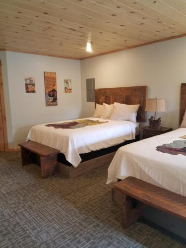 a hotel room with two beds and two benches at 406 Lodge at Yellowstone in Gardiner