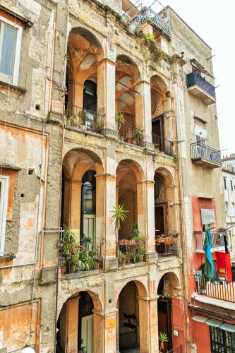 an old building with plants on the balconies at La Gatta Cenerentola Rooms in Naples