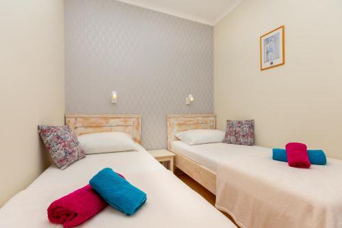 two beds with towels on them in a room at Siesta Ragusa in Dubrovnik