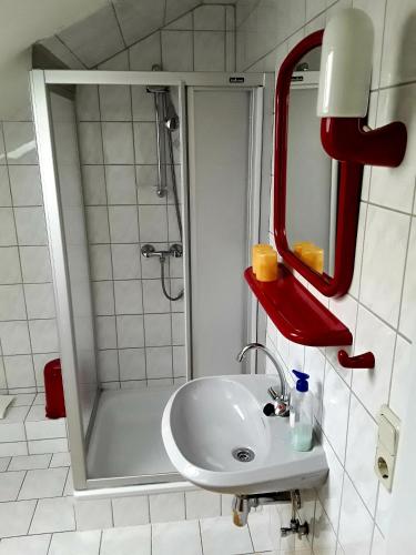 a bathroom with a white sink and a shower at Pension Hänsel in Ehrenberg
