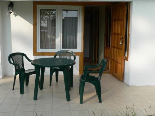 a green table and two chairs on a patio at Ośrodek Wypoczynkowy Perkoz in Okuninka