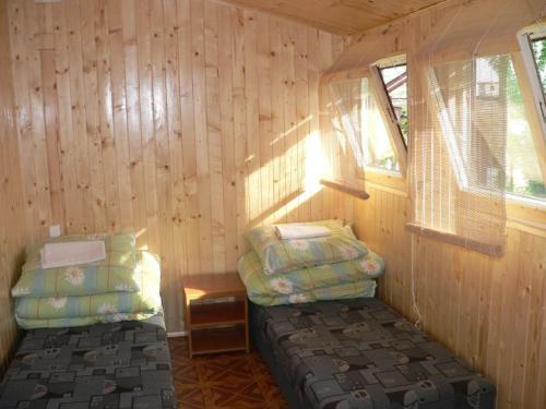 a room with two beds in a wooden cabin at Ośrodek Wypoczynkowy Perkoz in Okuninka