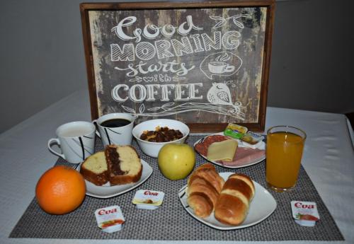 a table topped with plates of breakfast food and a chalkboard at Horta D'Alva in Castelo Branco