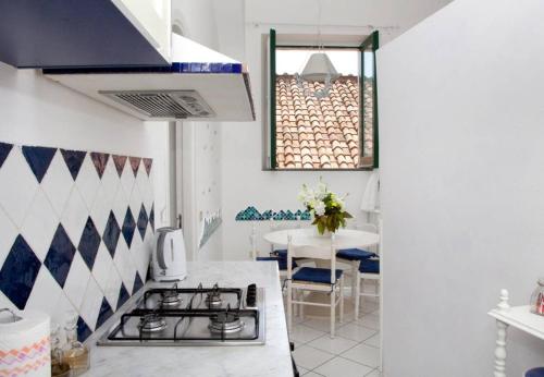 a kitchen with a stove and a table with a window at Brasca Amalfi Rosa Canina in Minori