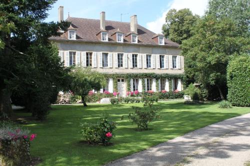 a large house with a green yard with flowers at Chateau de Longeville in Deux-Chaises