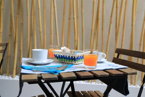 a table with drinks and a bowl of orange juice at Bed Nonnonino in Porto Cesareo