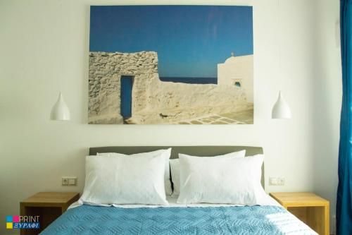 a bedroom with a bed with a painting on the wall at Evaggelia Design Suite in Nea Peramos