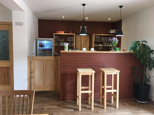 a bar with two stools next to a brick wall at Penzion REHEK in Malá Morávka
