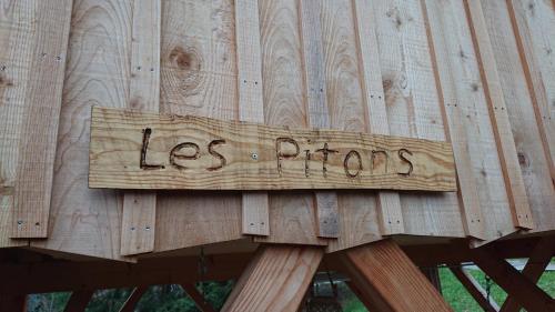 a sign on a wooden fence with the words les prios at Les Cabanes Du Saleve in Collonges-sous-Salève