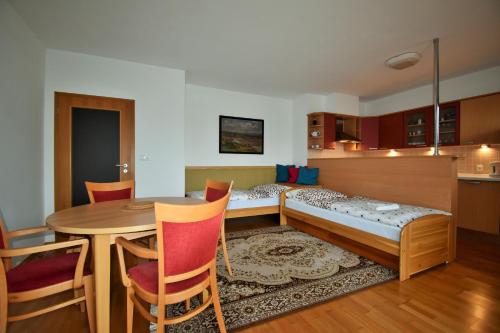 a room with a bed and a table and a kitchen at Apartmány Michael in Špindlerův Mlýn