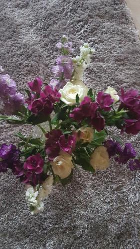 a bouquet of purple and white flowers on a rug at Rockhill hospitality in Coleraine