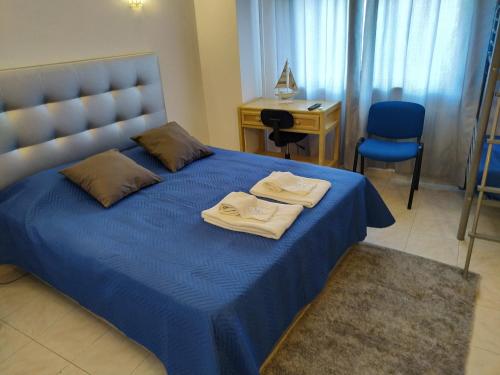 um quarto com uma cama azul com duas toalhas em AL "Hospedaria Por do sol" Sunset Olhao em Olhão