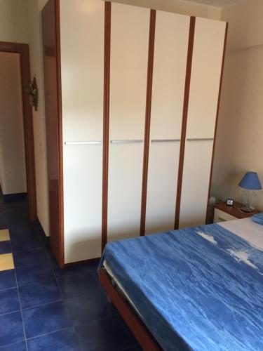 1 dormitorio con 1 cama y armario blanco grande en SANT'ALESSIO BEACH HOLIDAY, en SantʼAlessio Siculo