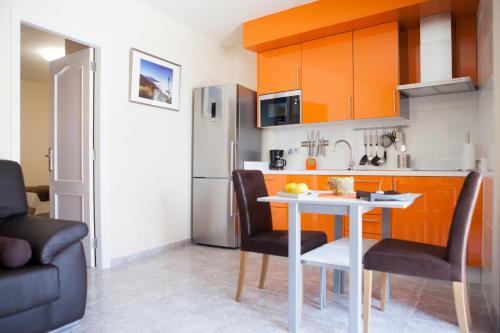 a kitchen with a table and chairs and a refrigerator at Casa Julia 1 Ático vista playa Las Teresitas in San Andrés