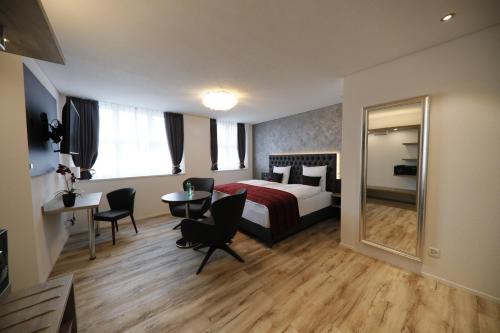 a hotel room with a bed and a table and chairs at Business Apartments Reichenburg in Reichenburg