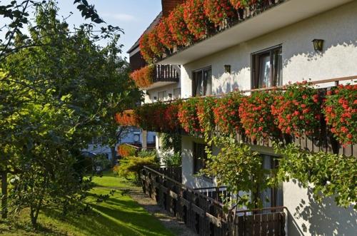 un bâtiment avec des fleurs rouges sur son côté dans l'établissement Hotel Riegeler Hof, à Riegel am Kaiserstuhl