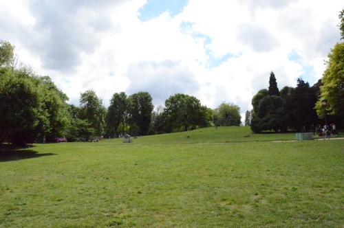 a large grassy field in a park with trees at Parc Hotel in Paris
