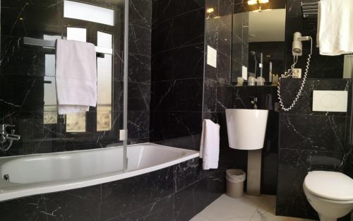 パリにあるパルク ホテルの黒いバスルーム(バスタブ、トイレ付)