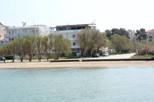 a building on the side of a beach next to the water at Ammos Hotel in Agia Triada