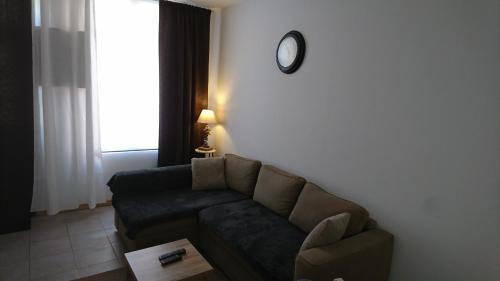 a living room with a couch and a clock on the wall at Gîte le tréportais in Le Tréport