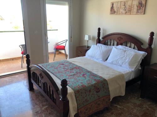 a bedroom with a large bed with a wooden frame at Casa de la Colina in Torre del Mar