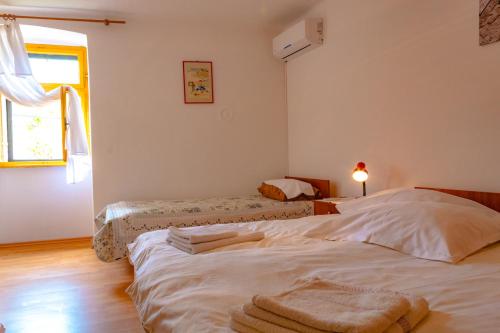 a bedroom with two beds with towels on them at Kuca za odmor Kornic in Kornić