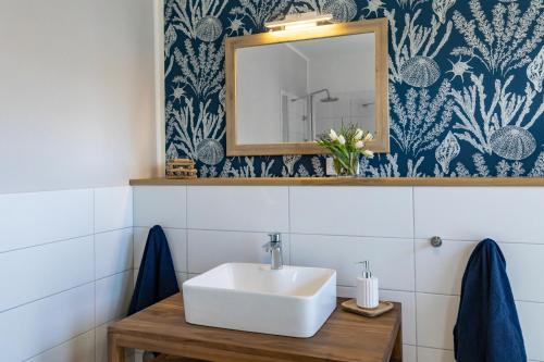 エッカーンフェルデにあるSEASIDE APARTMENTS - BEACHHOUSE BLUEのバスルーム(洗面台、鏡付)