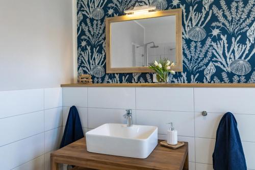 a bathroom with a sink and a mirror at SEASIDE APARTMENTS - BEACHHOUSE BLUE in Eckernförde