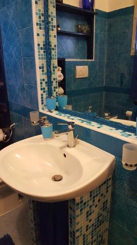 a bathroom with a white sink and a mirror at Da Adriana Guesthouse in Santa Teresa Gallura