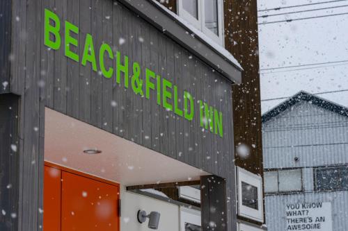 a building with the sign for a beaconsfield mall in the snow at BEACH AND FIELD INN in Sapporo