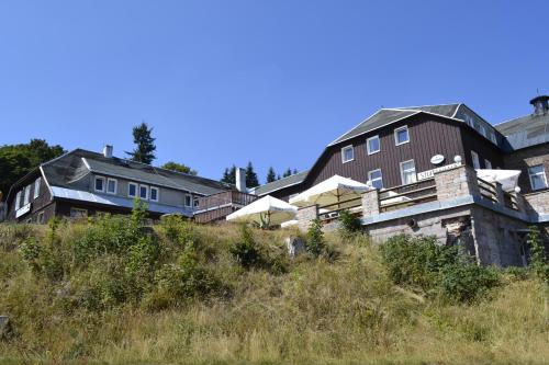 un grupo de casas sentadas en la cima de una colina en Berghotel Stutenhaus en Schmiedefeld am Rennsteig