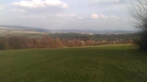 a large green field with mountains in the background at Agrowczasy in Wola Piotrowa