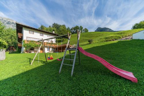 a playground with a slide in a yard at Trafisolerhof in Vols am Schlern